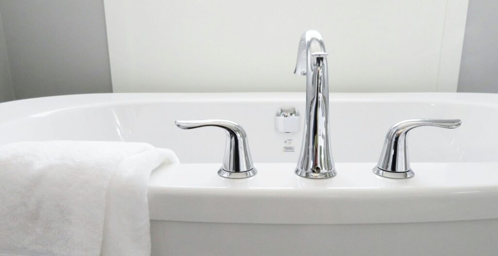 Clean and modern white bathtub with chrome fixtures, perfect for sleek interior design.